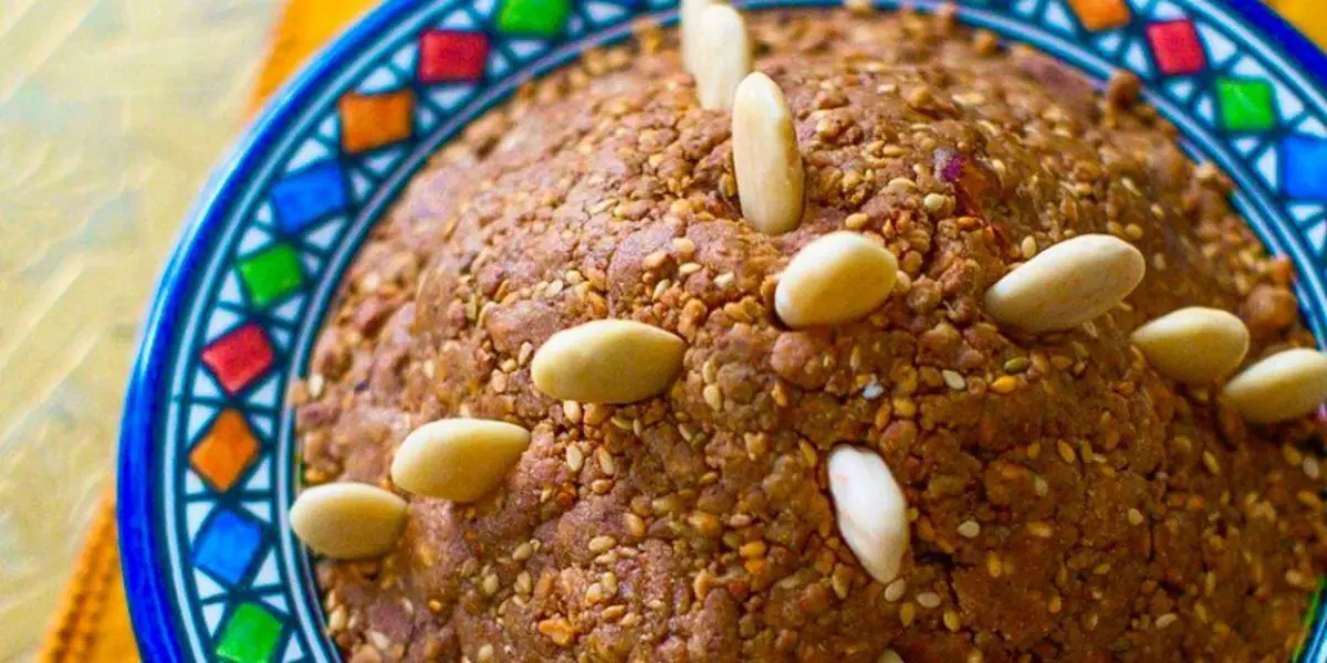 Traditional Moroccan Sellou pyramid decorated with fried whole almonds and powdered sugar